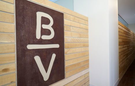 Bandera Ventures office brand letter b above v b divided by v b over v sign in empty hallway commercial real estate company based in dallas texas